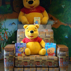 Photo of a cozy chair at the library with Winnie the Pooh books and stuffed toys