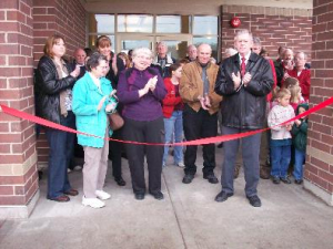 Photo of library supporters applauding at the ribbon cutting